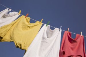 青空の下、風になびく洗濯物。清潔に洗い上げた衣類が天日干しされている様子