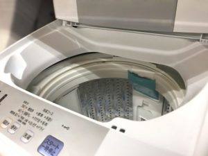 フタを開けた洗濯機の内部。洗濯槽の中は空で、洗濯機の掃除のイメージとして使用
